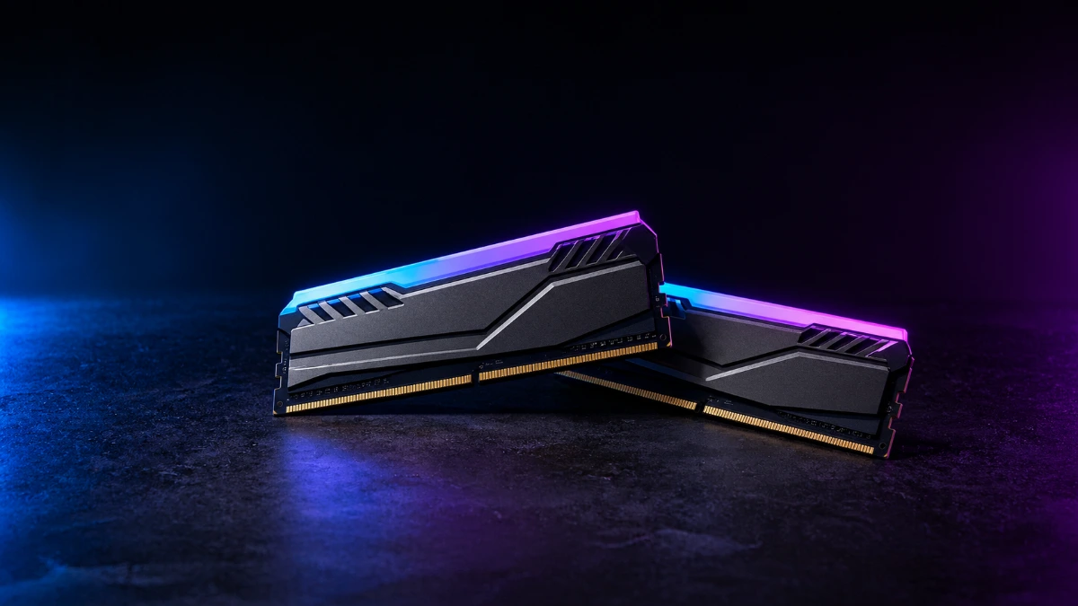Dos módulos de memoria RAM DDR5 con disipadores negros y grises y una tira de iluminación RGB azul y morada
